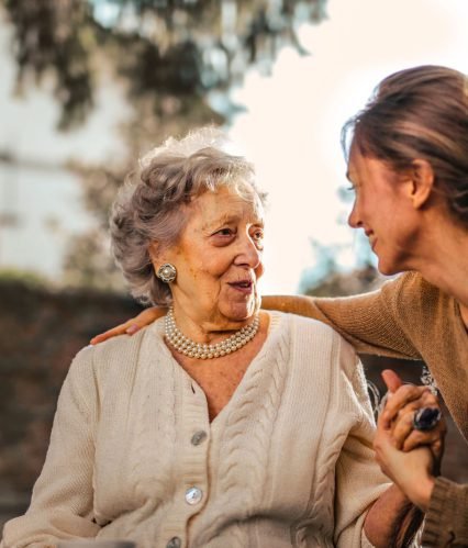 A caregiver and a family member in warm conversation at home